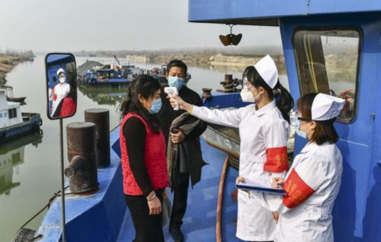 2月4日，台儿庄船闸节制闸服务中心人员对途经该水域的船民进行体温检测。新华社供图