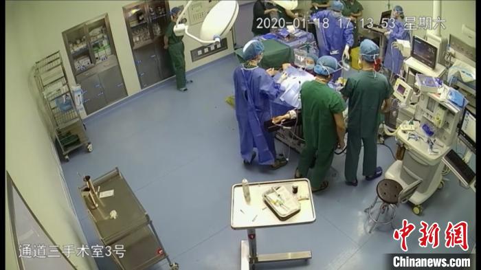 蒋雨露跪在手术台下托举胎儿头部。监控截图